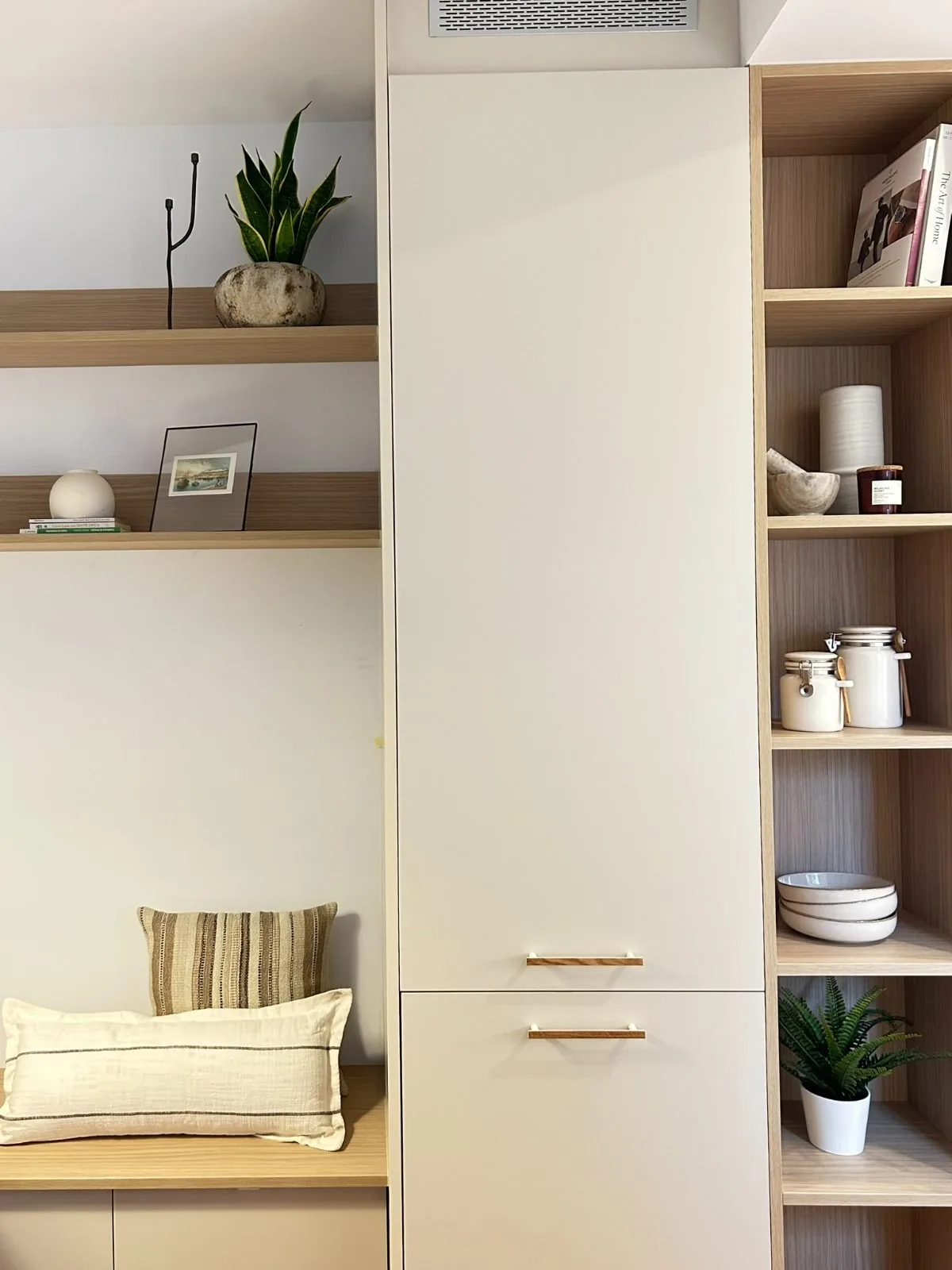 Armario alto blanco con estantería de madera y banco con cojines