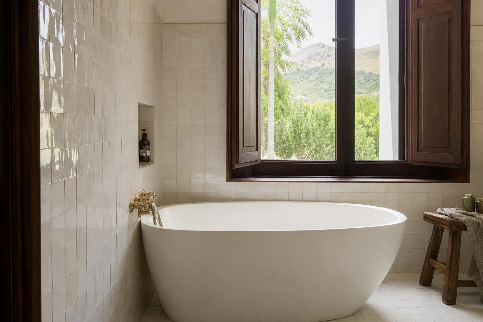 Baño con bañera exenta junto a la ventana y azulejo artesanal blanco