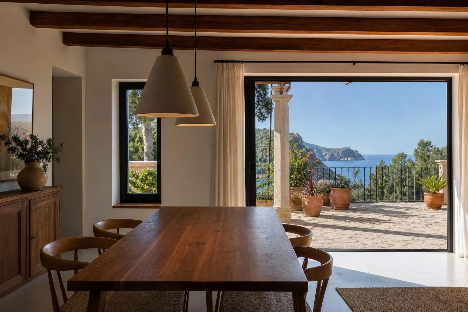 Comedor con mesa de madera y lámparas colgantes junto a una terraza